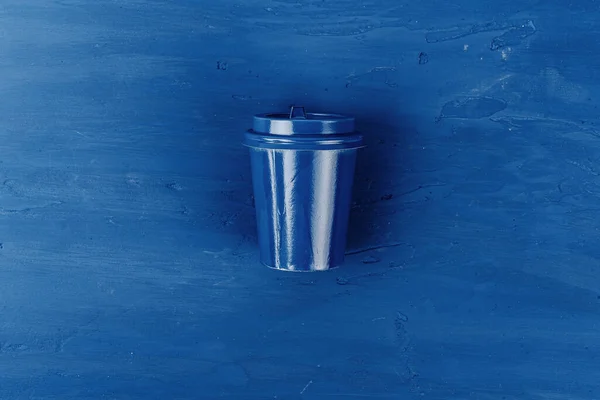 Vista superior de una taza de café para llevar sobre fondo azul clásico —  Fotos de Stock