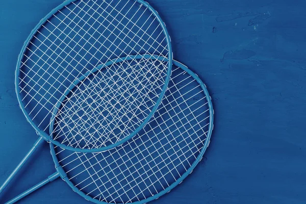 Raquetas de bádminton sobre fondo azul clásico, vista superior — Foto de Stock