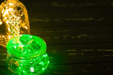 Cam saklama kavanozuna ampullü yeşil çelenk.