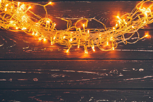 Рождественская гирлянда на деревянном фоне с копировальным местом
