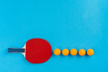 Mavi arka planda pinpon raketi ve top.