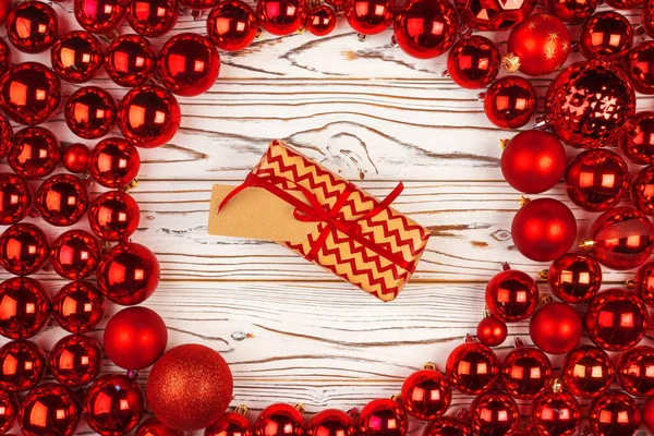 Kırmızı parlak mücevherlerle çevrili Noel hediyesi.