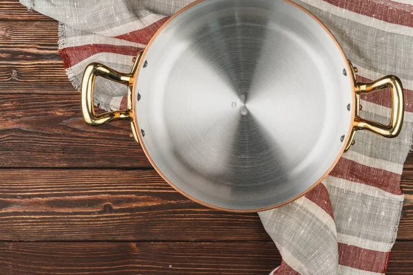 Pote de cobre com toalha de mesa chekered na mesa de madeira — Fotografia de Stock