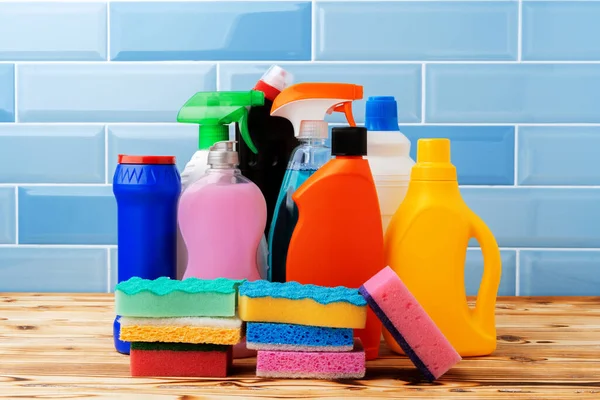 Бытовые моющие средства и чистящие средства на фоне синей плитки — стоковое фото