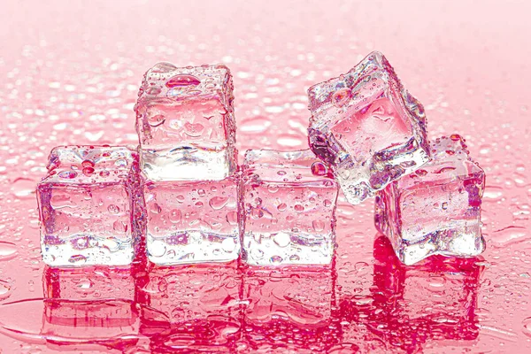 湿粉色背景上的冰冻冰块 — 图库照片