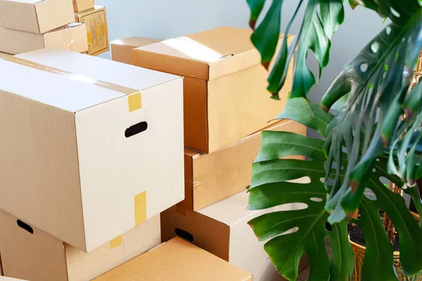 Koncept pohybu domu s skládanými lepenkovými krabicemi v místnosti — Stock fotografie