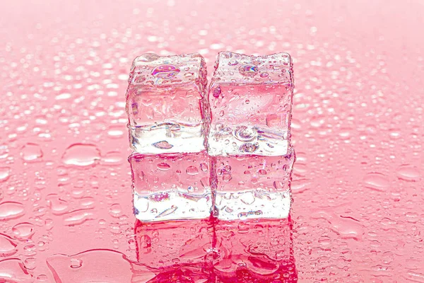 Fozen kostki lodu na mokrym różowym tle — Zdjęcie stockowe