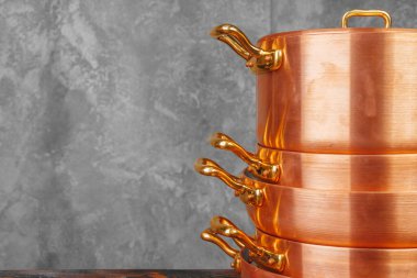 Ahşap masada bakır tencere yığını. Yakın çekim.