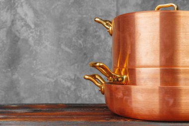 Ahşap masada bakır tencere yığını. Yakın çekim.