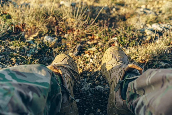 Hombre viajero en botas de senderismo se sienta en la parte superior — Foto de Stock