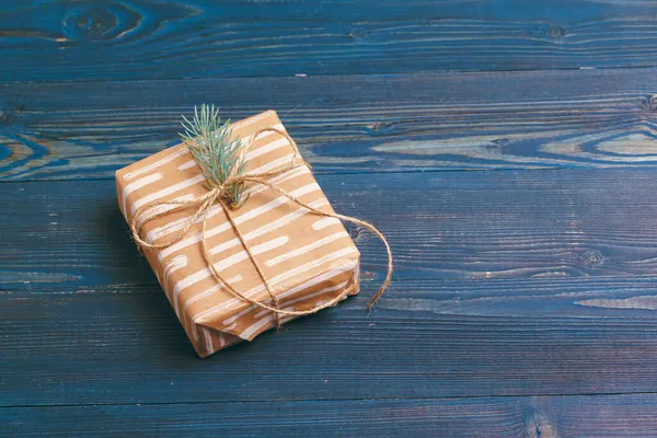Christmas gifts with fir tree branches on wooden background — Stock Photo, Image