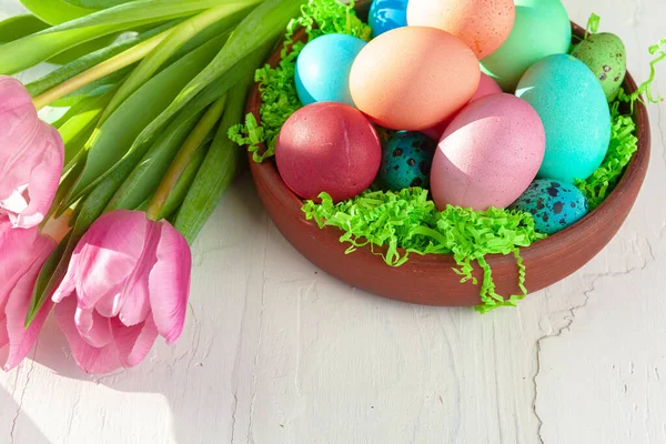 Composição de Páscoa com tulipas e cesta de ovos pintados — Fotografia de Stock