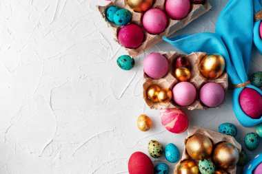 Beyaz kabartmalı arka planda parlak boyanmış Paskalya yumurtaları kompozisyonu