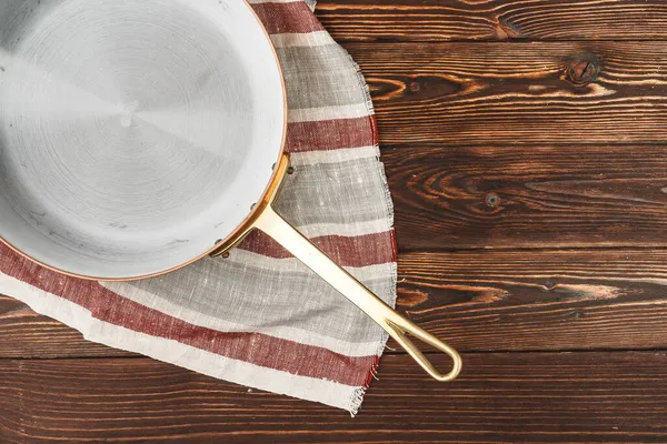 Pote de cobre com toalha de mesa chekered na mesa de madeira — Fotografia de Stock