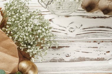 Çiçekli Paskalya kompozisyonu için altın renkli yumurtalar.