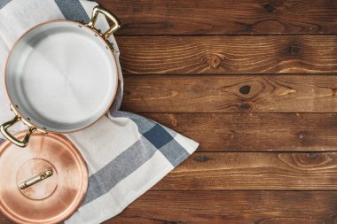 Ahşap tahtada temiz bakır mutfak malzemeleri.