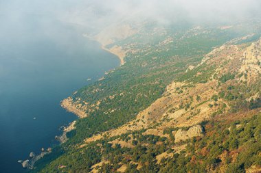 Sabah sisli arka planda ormanları olan güzel dağ.