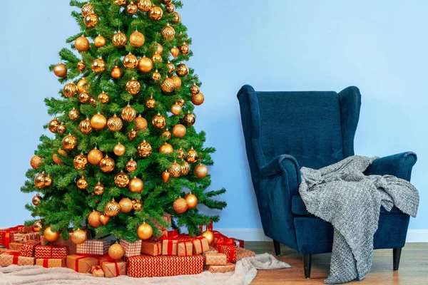 Interior de férias. Bela árvore de natal decorada com poltrona azul — Fotografia de Stock