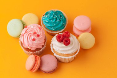 Sarı bir arka plan üzerinde krema ile lezzetli cupcakes