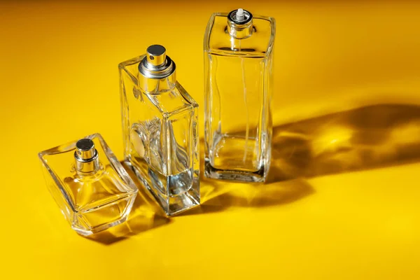 Szklana butelka perfum na jasnożółtym tle. Woda toaletowa — Zdjęcie stockowe