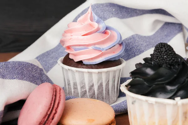 Deliciosos cupcakes de framboesa e caramelo no fundo escuro — Fotografia de Stock