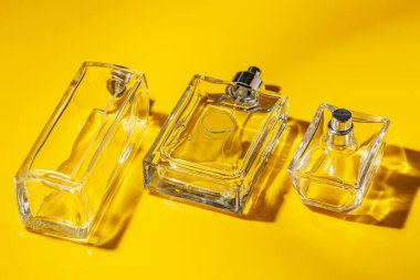 açık sarı arka plan üzerinde parfüm cam şişe. Eau de toilette
