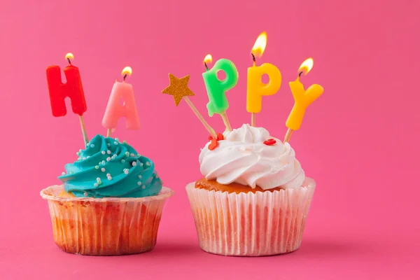 Heerlijke cupcakes met kaarsen op een gekleurde achtergrond. Feestelijke achtergrond, verjaardag — Stockfoto