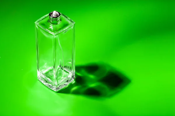 Frasco de vidrio perfume sobre fondo verde claro. Eau de toilette — Foto de Stock
