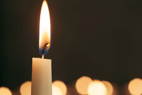 Одна горіння свічка ізольована з чорним тлом — стокове фото