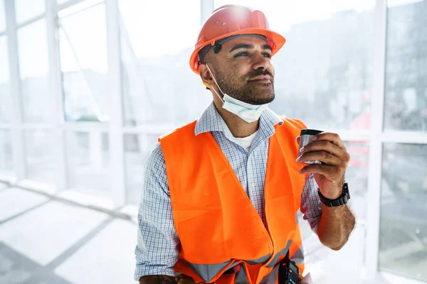 Retrato de um homem trabalhador em roupas de trabalho em uma pausa beber café e descansar — Fotografia de Stock