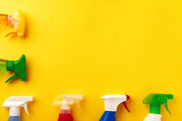 Очистка бутылок с моющим средством на желтом фоне — стоковое фото