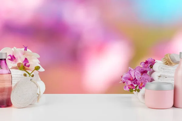 Πετσέτες με λουλούδια στο φωτεινό τραπέζι σε θολή φόντο — Φωτογραφία Αρχείου