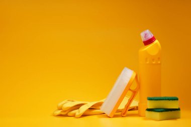 Sarı stüdyo arka planında ev temizleme araçları