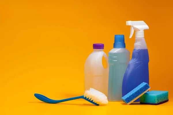 Reinigungsmittelflaschen auf gelbem Hintergrund — Stockfoto