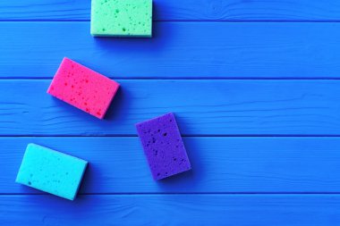 Mavi ahşap arka planda süngerleri temizleme düzlüğü