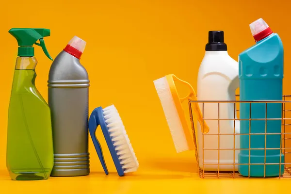 Botellas de detergente de limpieza de la casa sobre fondo amarillo — Foto de Stock