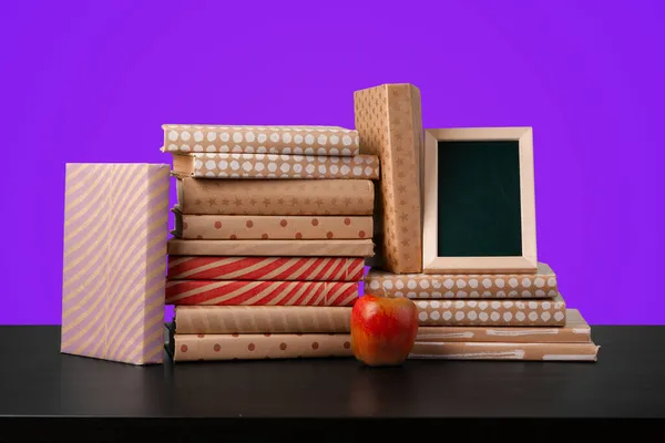Concepto de educación con pila de libros sobre una mesa sobre fondo de color. — Foto de Stock