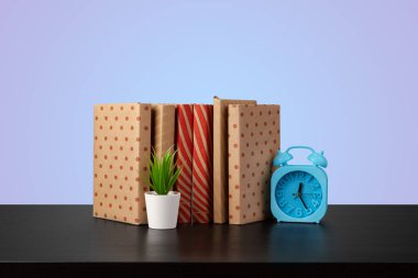 Renkli arka plana karşı bir masanın üzerinde kitap yığını olan eğitim kavramı.