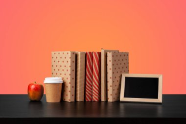 Renkli arka plana karşı bir masanın üzerinde kitap yığını olan eğitim kavramı.