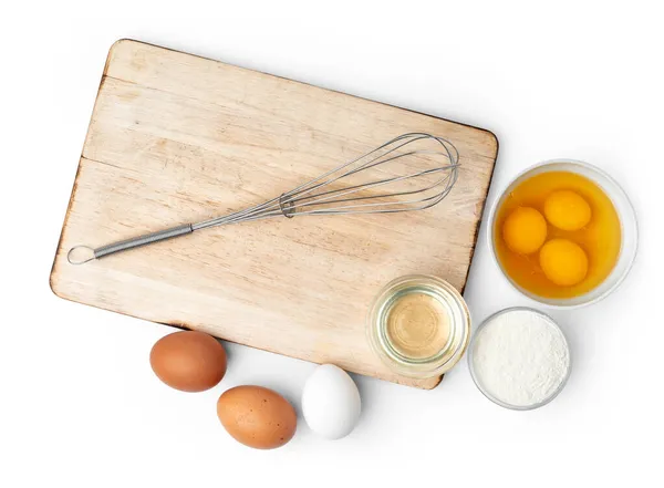Металлический венчик и яйца для приготовления пищи изолированы на белом — стоковое фото