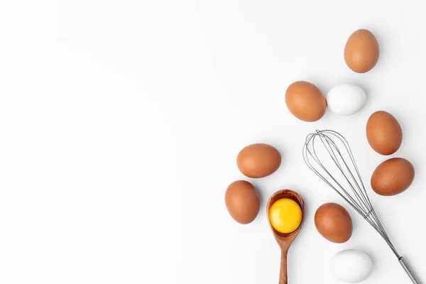 Свежие яйца с венчиком на белом фоне — стоковое фото