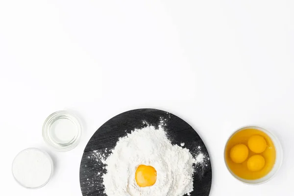 Ακατέργαστος κρόκος αυγού σε σωρό αλεύρου σε λευκό φόντο — Φωτογραφία Αρχείου