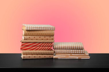 Renkli arka plana karşı bir masanın üzerinde kitap yığını olan eğitim kavramı.