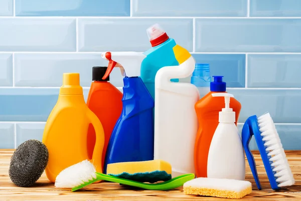 Detergenti per uso domestico e strumenti di pulizia sullo sfondo blu delle piastrelle — Foto Stock