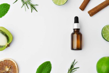 Beyaz arka planda gerekli yağ şişeleri ve narenciye meyvesi