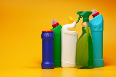 Sarı arka planda ev temizleme deterjanı şişeleri