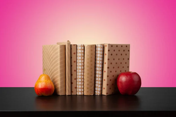 Concepto de educación con pila de libros sobre una mesa sobre fondo de color. — Foto de Stock