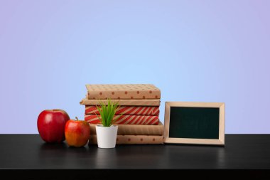 Renkli arka plana karşı bir masanın üzerinde kitap yığını olan eğitim kavramı.