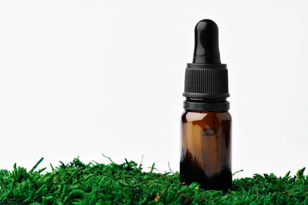 Botella de aceite aromático para la medicina herbal entre el musgo verde natural — Foto de Stock