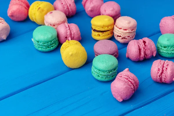 Montón de deliciosos macarrones de colores sobre fondo azul —  Fotos de Stock